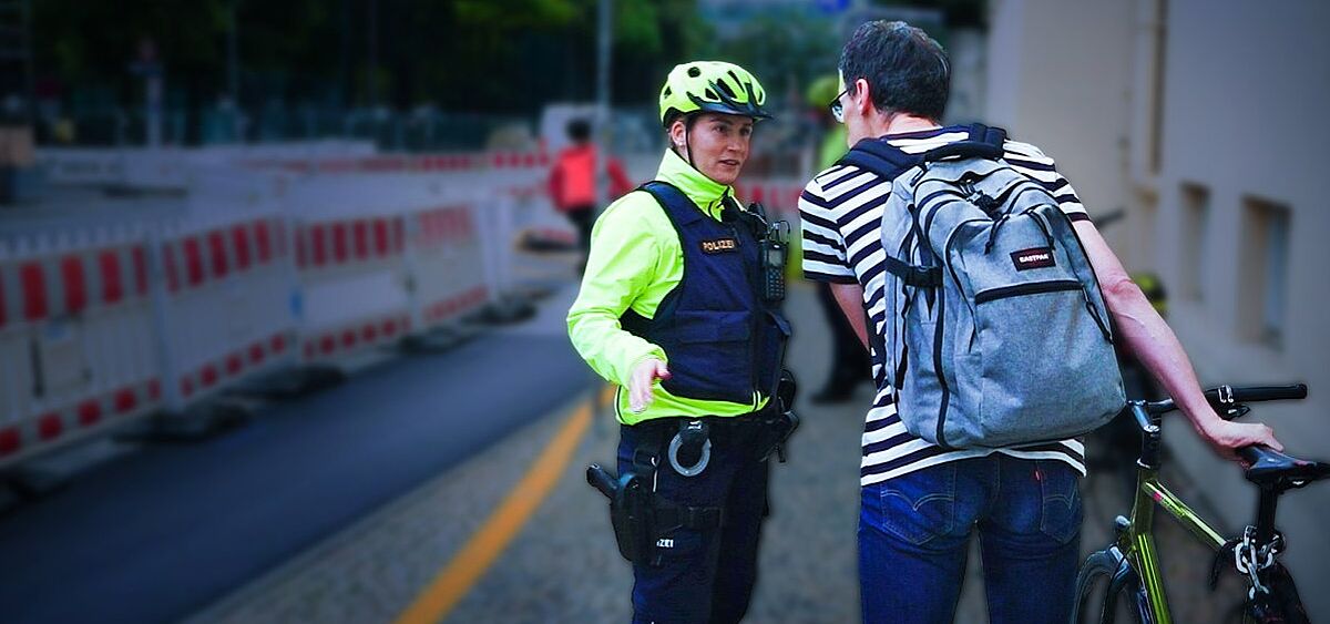 Fahrradstreife Polizistin spricht mit Radfahrer