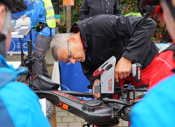 Mann mit Codiergerät codiert ein Fahrrad