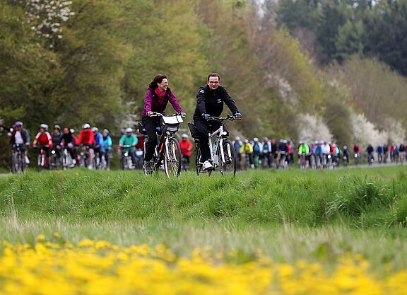 Anradeln im Rodachtal Zu sehen ist eine Gruppe Radfahrern, im Vordergrund Blumenwiese und im Hintergrund Bäume